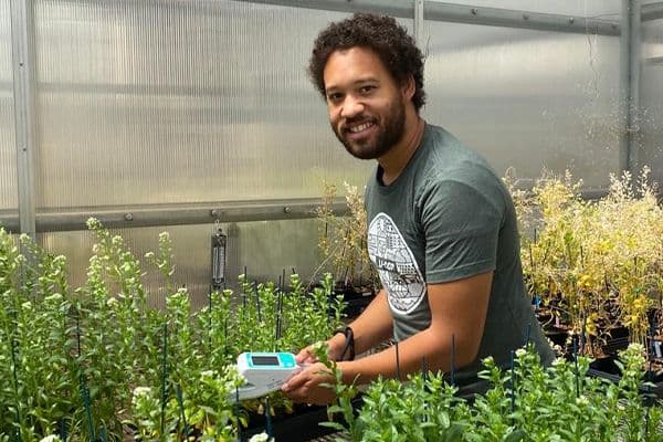 Jason Thomas using the LI-600 to measure plants in a greenhouse.